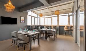 Treebo Liyan Orchid, Hsr Layout في بانغالور: غرفة طعام مع طاولات وكراسي وتلفزيون