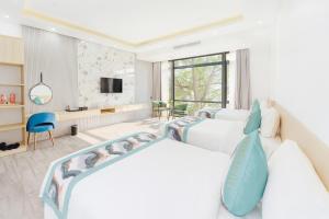 a bedroom with two beds and a tv at Sala Home Móng Cái in Móng Cái