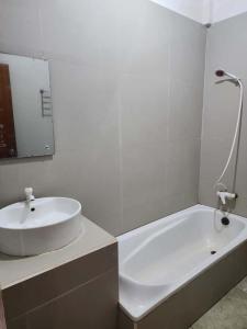 a white bathroom with a sink and a bath tub at kalaki beach hotel in Daru