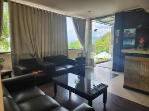 a living room with couches and a coffee table and a room withwindows at kalaki beach hotel in Daru