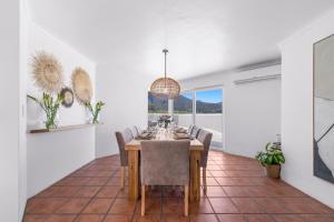 开普敦Pingu Beachhouse with Jacuzzi Hout Bay Cape Town的餐厅里有一张桌子和几把椅子