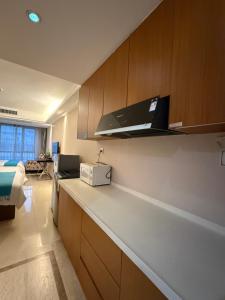 a kitchen with a counter top with a microwave at WAIFIDEN Apartment Min Jian Financial Building-Free shuttle bus during the Canton Fair in Guangzhou