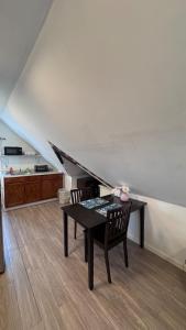 a living room with a table and chairs and a staircase at Loft Private Studio -- Washer and Dryer -- Near Boston Transit in Malden