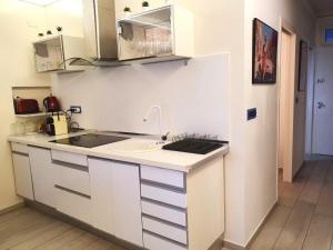 une cuisine blanche avec un évier et un comptoir dans l'établissement FACE MER TOUT CONFORT situation exceptionnelle, à Antibes