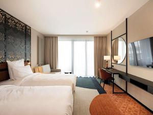 Una habitación de hotel con dos camas y un televisor. en Mercure Szczyrk Resort, en Szczyrk