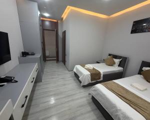 a hotel room with two beds and a television at Samanid hotel in Salor Bekati