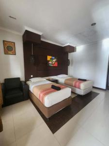 a hotel room with two beds and a chair at kalaki beach hotel in Daru