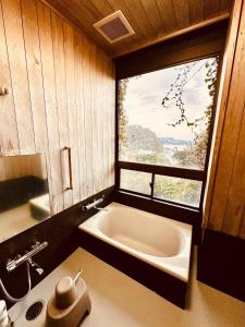 une salle de bain avec une baignoire et une fenêtre dans l'établissement Izu Base 73 - Vacation STAY 18722v, à Okawa