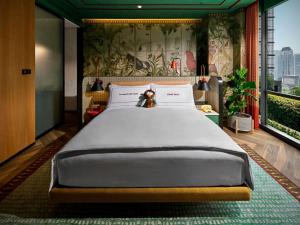a large bed in a room with a large window at 25hours Hotel Jakarta The Oddbird in Jakarta