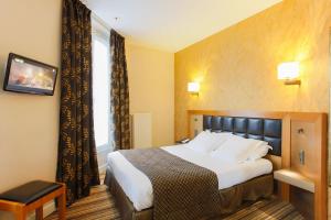a hotel room with a bed and a window at Hotel Bellevue Saint-Lazare in Paris