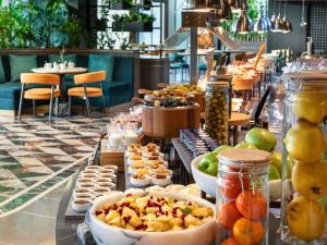 una linea a buffet con ciotole di frutta e altri prodotti alimentari di Mövenpick Hotel Istanbul Marmara Sea a Istanbul