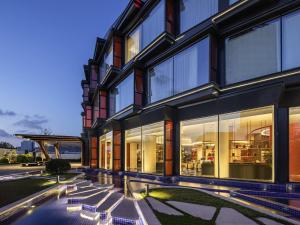 an exterior view of a building with large windows at Movenpick by Accor Qingdao Sunmei in Qingdao
