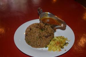 a plate of food with rice and coleslaw on a table at Big Spoon Cafe in Eldoret