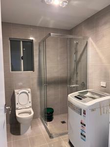 ein kleines Badezimmer mit Toilette und Dusche in der Unterkunft North Parrramatta, NSW 2151 in Sydney