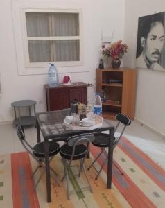 圣路易斯Keur Fall Aéroport appartement f4的一间带桌子和四把椅子的用餐室