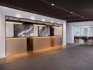 a lobby with tables and chairs in a building at Mercure Saga Karatsu Resort in Karatsu