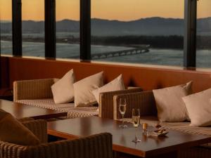 un restaurant avec des canapés et une table avec des verres à vin dans l'établissement Grand Mercure Lake Hamana Resort & Spa, à Hamamatsu