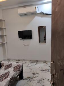 a room with a tv and a mirror on a wall at Narayan Home Stay in Ujjain +11 photos