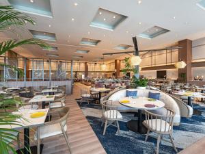 obraz restauracji ze stołami i krzesłami w obiekcie Grand Mercure Wakayama Minabe Resort & Spa w mieście Minabe