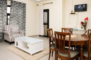 a living room with a dining room table and chairs at Ste Raphaelle Guest House in Yaoundé