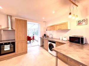 une cuisine avec un évier et une cuisinière dans l'établissement Le Forterre - 2 chambres - Parking - Jardin, à Toucy