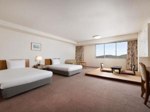 una habitación de hotel con dos camas y un sofá en Mercure Wakayama Kushimoto Resort & Spa, en Kushimoto 73 fotos más