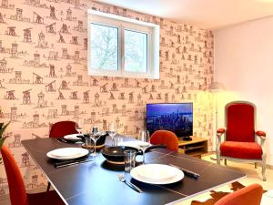 une salle à manger avec une table et des chaises rouges dans l'établissement Le Forterre - 2 chambres - Parking - Jardin, à Toucy 30 autres photos