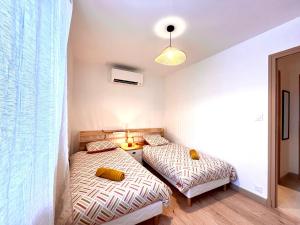 - 2 lits dans une petite chambre avec antemottermottermottermotmotmotmott dans l'établissement Le Forterre - 2 chambres - Parking - Jardin, à Toucy