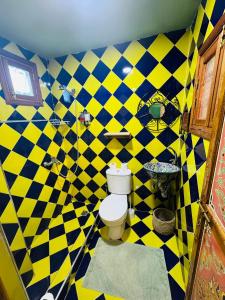Un baño a cuadros amarillos y azules con inodoro. en Riad Moroccan Style, en Fez 81 fotos más