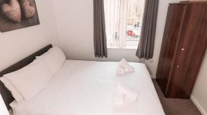 une chambre avec un lit avec deux oreillers blancs dessus dans l'établissement Greenings Apt Warrington - 2 Bed with FREE off road Parking & Wifi, à Warrington