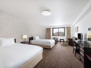 ein Hotelzimmer mit zwei Betten und einem Fernseher in der Unterkunft Mercure Miyagi Zao Resort & Spa in Zao + 96 Fotos