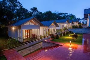 a villa with a garden at night at Cardamom Village Hill Resort by EGH in Thekkady