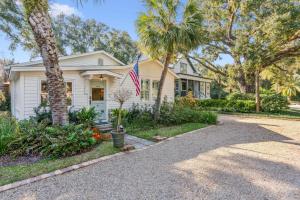 ein weißes Haus mit einer amerikanischen Flagge in der Einfahrt in der Unterkunft Endless Summer - 4217 - 6th Street in Saint Simons Island