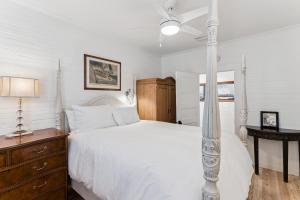 - une chambre avec un lit blanc et une commode en bois dans l'établissement Endless Summer - 4217 - 6th Street, à Île de Saint-Simon 34 autres photos