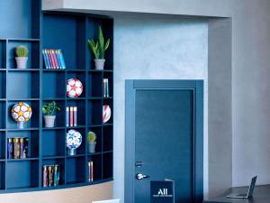 a room with a blue door and a book shelf with plants at ibis Styles Batumi Hotel in Batumi