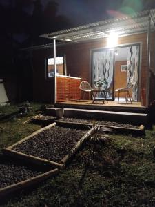 a house with a patio with two chairs and a table at Bungalow des palmistes in Saint-Benoît