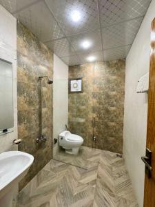 un bagno con un water e un lavandino di Holiday One Hotel & Suites a Karachi