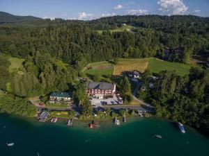 una vista aerea di una grande casa su un lago di Seehotel Vinzenz a Velden am Wörthersee