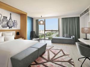 een slaapkamer met een groot bed en een woonkamer bij Mövenpick Hotel & Apartments Ghala Muscat in Muscat +218 foto's