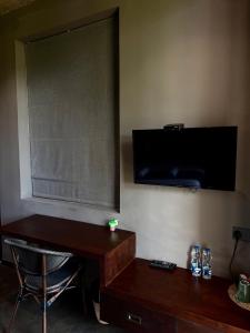 a room with a desk and a television on the wall at West nest Bohemian in Negombo