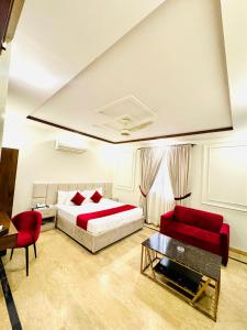 una camera da letto con un letto, un divano e un tavolo di Holiday One Hotel & Suites a Karachi