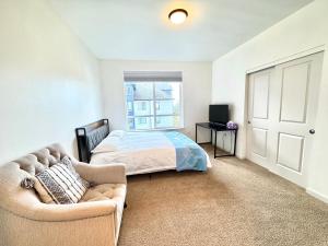 a bedroom with a bed and a couch and a window at 2B2B apartment with stunning window -7min to Dome in Tacoma