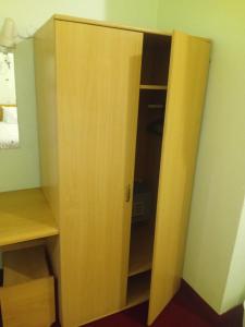 a closet with a wooden door in a room at Brackendene Lodge in Gaborone
