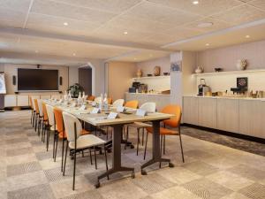 a large conference room with a long table and chairs at Mercure London Earls Court in London +174 photos