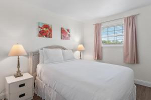 Un dormitorio blanco con una cama blanca y una ventana. en Beachy Keen, en Destin 73 fotos más