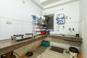 a kitchen with a sink and a orange hose at Pretty Garden View Apartment 3BHK Furnished Flat near Kashi Vishwanath Temple in Varanasi +138 photos