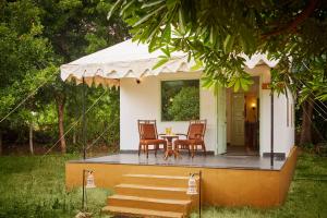 a small house with a table and chairs on the porch at Varawal Leopard Camp in Mori Bera