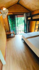 ein Schlafzimmer mit großem Bett und Holzboden in der Unterkunft โฮมสเตย์ เนเจอร์ เดอ สะปัน Nature De Sapan in Ban Huai Ti