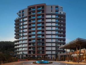 un immeuble de grande hauteur avec un rond-point devant. dans l'établissement Mövenpick Living Istanbul Saklivadi, à Istanbul