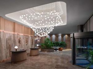 un hall d'entrée avec un grand lustre dans un immeuble dans l'établissement Mövenpick Living Istanbul Saklivadi, à Istanbul